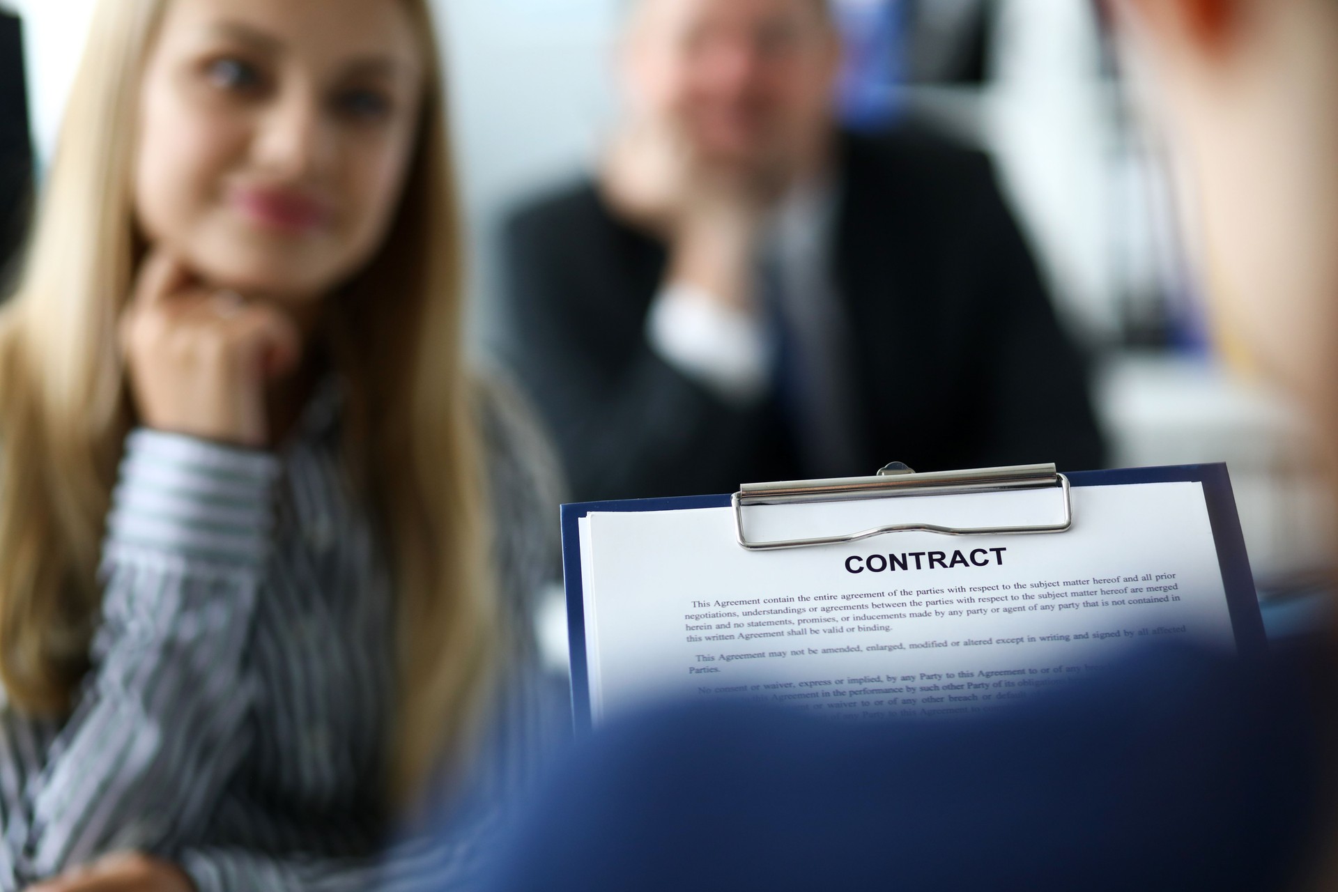 Visitor examining contract application form clipped to pad